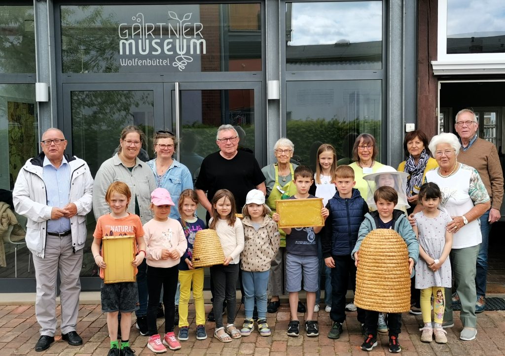 Imker Horst Janke (Mitte) mit den Kindern, Betreuerinnen und Ehrenamtlichen des Gärtnermuseums.