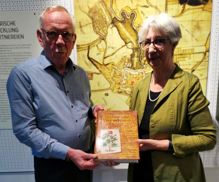 Christian Hogrefe nimmt das Buchgeschenk von Jill Bepler entgegen.